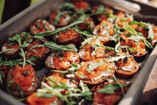 a lot of crispy toasts with salmon, arugula and soft cheese for dinner