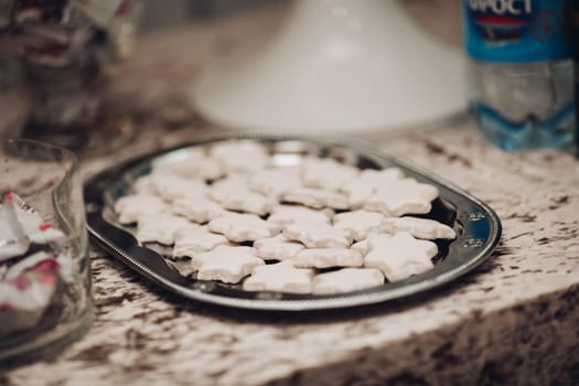 picture of a big silver plate with a lot of homemade white star cookies on the table