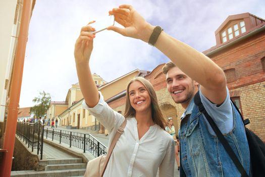 Happy couple of tourists taking selfie in old city.