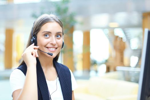 Woman customer support operator with headset and smiling