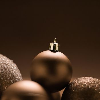 Christmas holiday and festive decoration concept. Golden baubles on beige background.