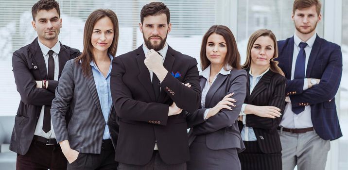 close-knit business team standing next to each other and arms crossed in front of him in the lobby of the office