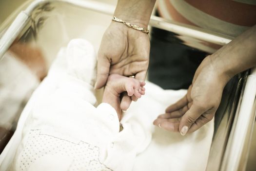 mother and newborn baby.close-up of mom's hand and foot of a newborn.photo with blank space for text