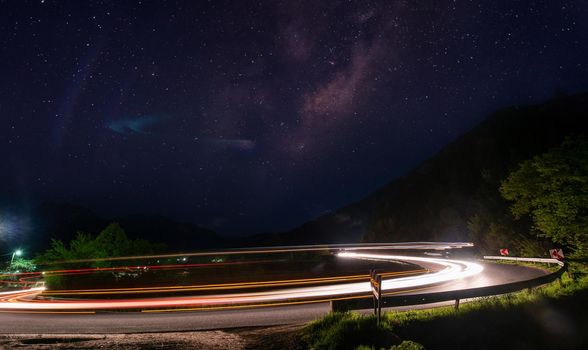 vegicle light trails in night on busy countryroad curve  long exposure