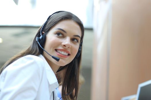 Female customer support operator with headset and smiling.