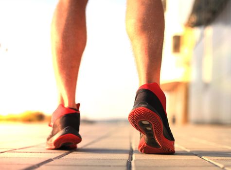 African man legs running while exercising outdoors, at sunrise or sunset.