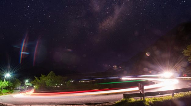 vegicle light trails in night on busy countryroad curve  long exposure