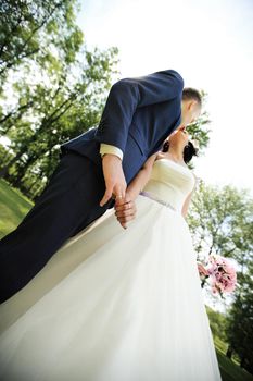 bottom view. kiss of the bride and groom.photo on the background of the Park.