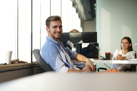 Portrait of young man sitting at his desk in the office