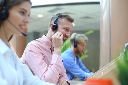 Attractive positive young businesspeople and colleagues in a call center office.