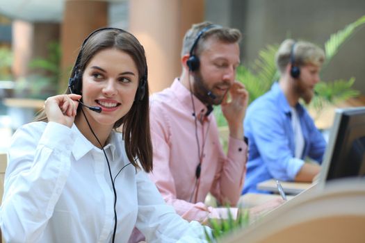 Attractive positive young businesspeople and colleagues in a call center office.