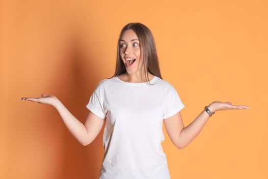 Young woman in casual clothing wondering and screaming isolated over yellow background.