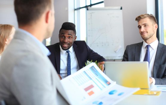 Business people in discussing something while sitting together at the table.