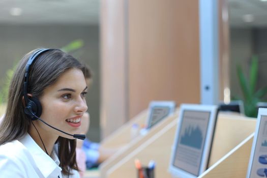 Female customer support operator with headset and smiling.