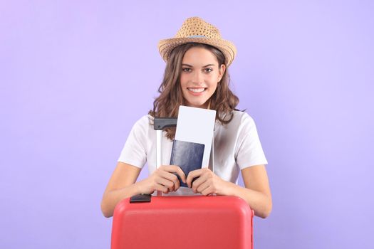 Young tourist girl in summer casual clothes, with sunglasses, red suitcase, passport isolated on purple background