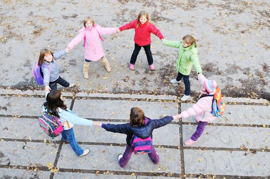 happy young child group outdoor standing together in circle formation and representing teamwork and friendship concept