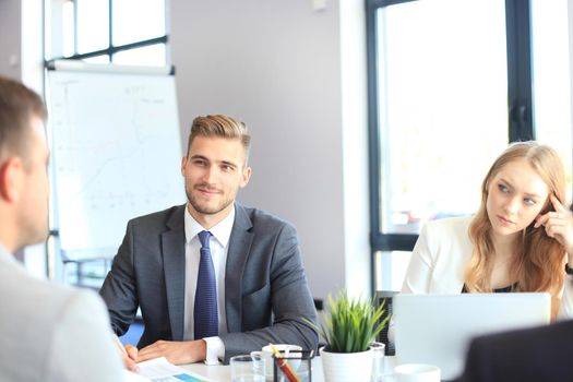 Business people in discussing something while sitting together at the table.