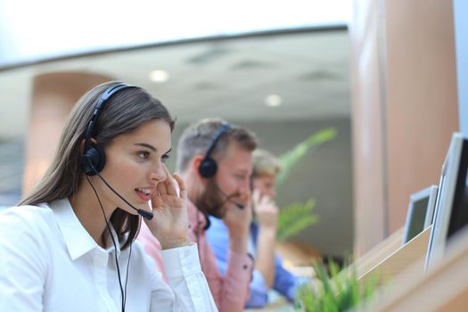 Attractive positive young businesspeople and colleagues in a call center office.