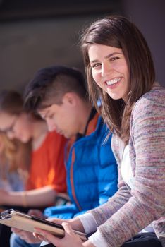 students group working on school  project  together on tablet computer  at modern university