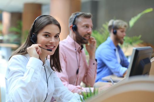 Attractive positive young businesspeople and colleagues in a call center office.