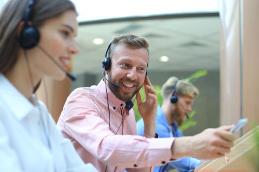 Attractive positive young businesspeople and colleagues in a call center office.