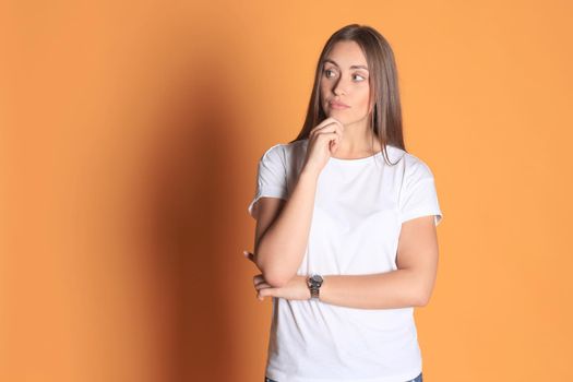 Image of thoughtful young woman posing isolated on yellow background