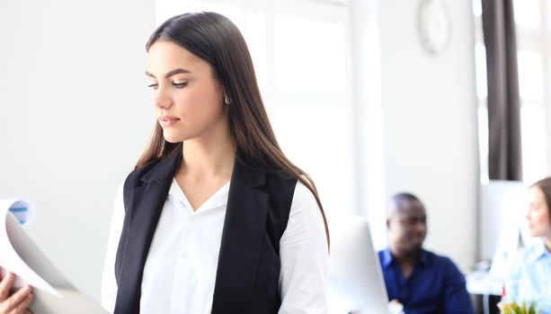 business woman with her staff, people group in background at modern bright office.