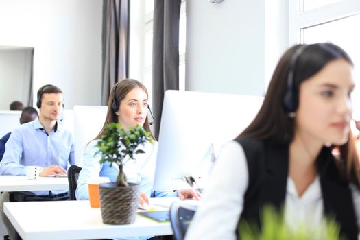 Attractive positive young businesspeople and colleagues in a call center office