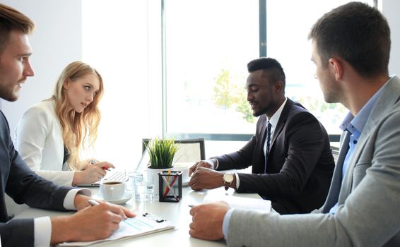 Business people in discussing something while sitting together at the table.