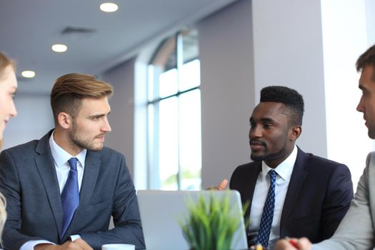 Business people in discussing something while sitting together at the table.