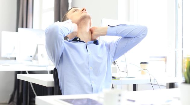 Portrait of a delighted businessman relaxing in his office