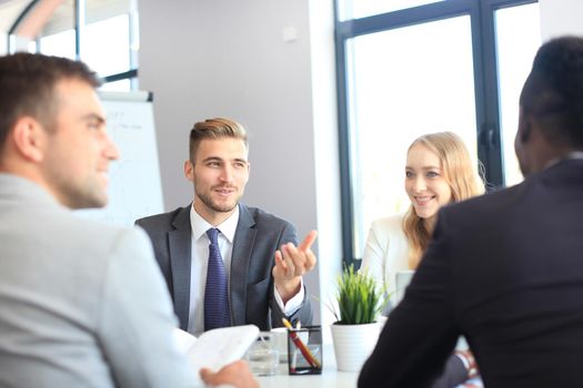 Business people in discussing something while sitting together at the table.