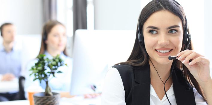 Attractive positive young businesspeople and colleagues in a call center office