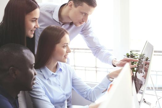 Team of colleagues brainstorming together while working on the computer