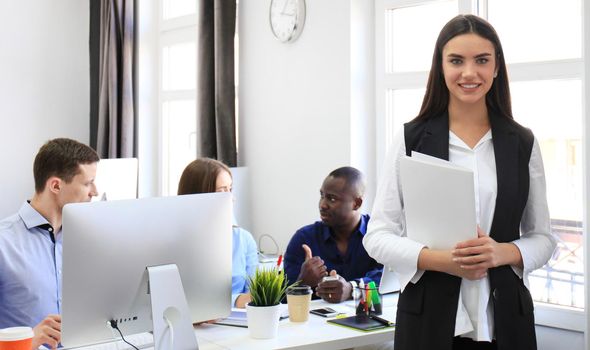 business woman with her staff, people group in background at modern bright office indoors