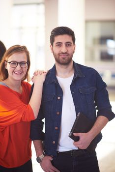 happy students couple standing together at university campus interior