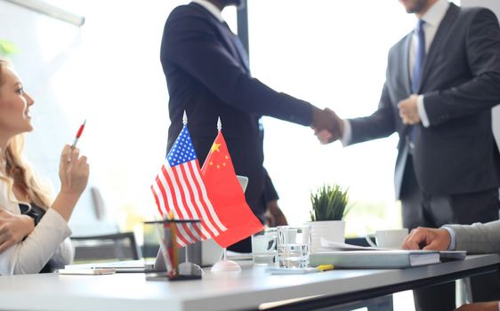 Chinese and American leaders shaking hands on a deal agreement.