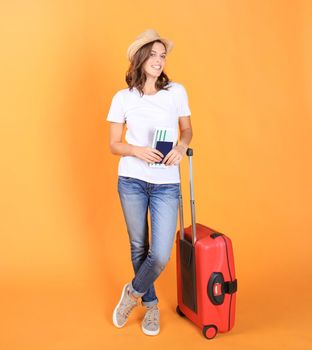 Young tourist girl in summer casual clothes, with red suitcase, passport, tickets isolated on beige background