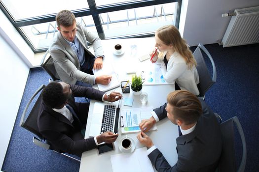 Business people in discussing something while sitting together at the table.