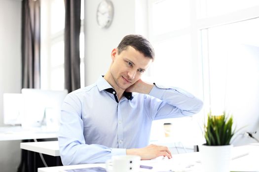 Portrait of a delighted businessman relaxing in his office