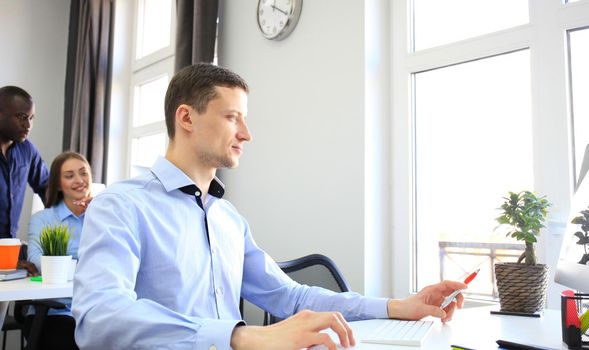 Businessman with colleagues in the background in office