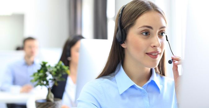 Attractive positive young businesspeople and colleagues in a call center office