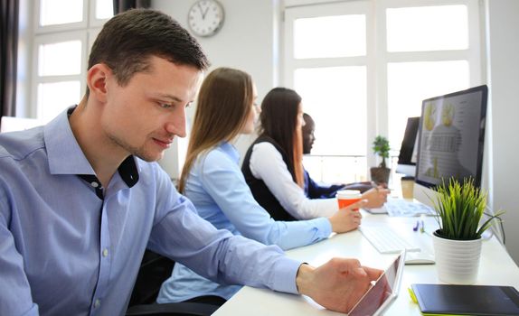 Team of colleagues brainstorming together while working on the computer