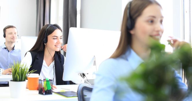 Attractive positive young businesspeople and colleagues in a call center office