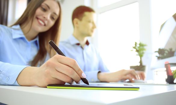 Graphic designer using digital tablet and computer in the office