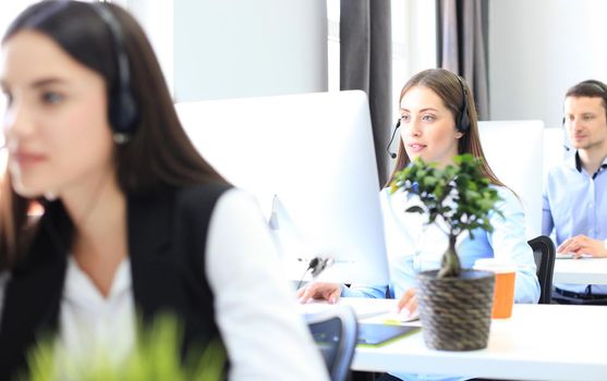 Attractive positive young businesspeople and colleagues in a call center office