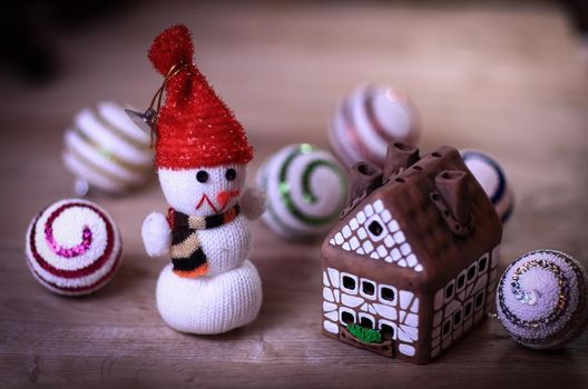 toy snowman and gingerbread house at the Christmas table .photo with copy space.