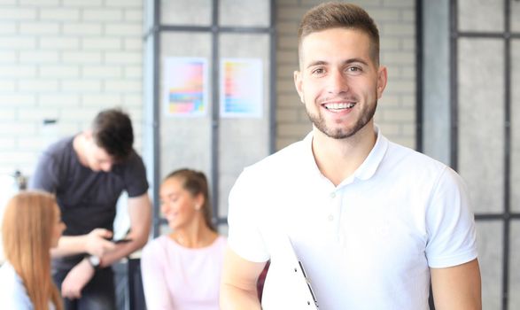 Businessman with colleagues in the background in office