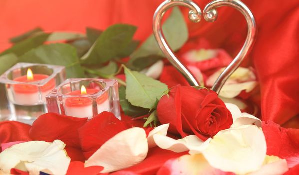 Valentine's Day. close up.roses and two candles on red background