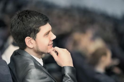 successful businessman in the ground sitting behind at a business conference.